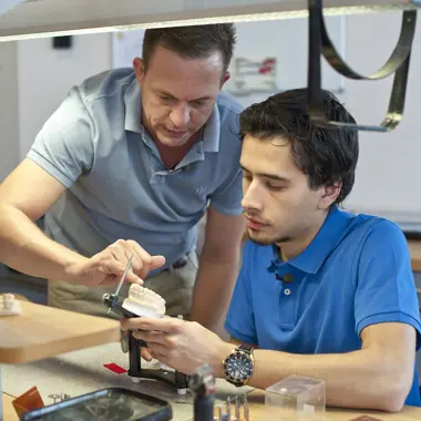 Student ontvangt instructies over het vervaardigen van tandtechnisch kroon- en brugwerk in een leeromgeving.