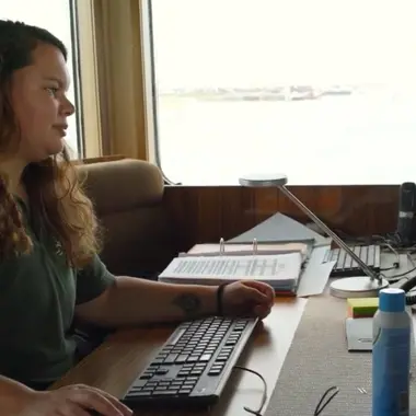 Mbo-student werkt met navigatieapparatuur aan boord van schip, gericht op technische vaardigheden en teamwork