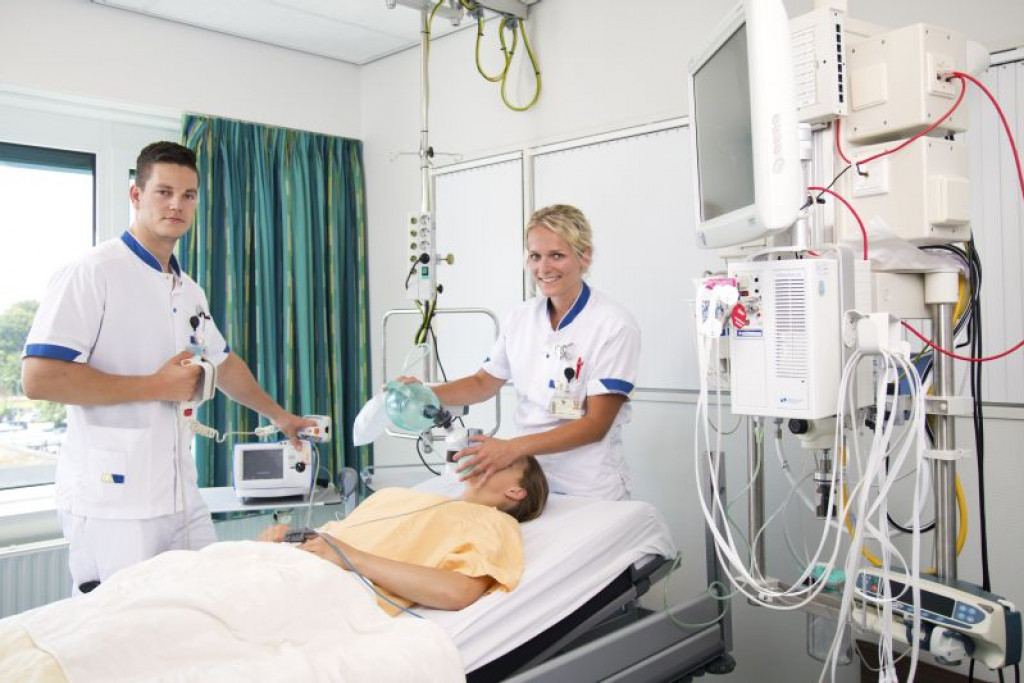 Verpleegkundigen oefenen medische handelingen met een patiënt in een klinische leeromgeving.