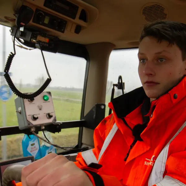 Leerling werkt met tractor en bedient machines voor onderhoud groen in buitengebied