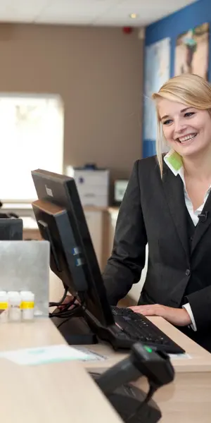 Toerisme-medewerkers bij balie in gesprek met klant over reisadvies en serviceverlening