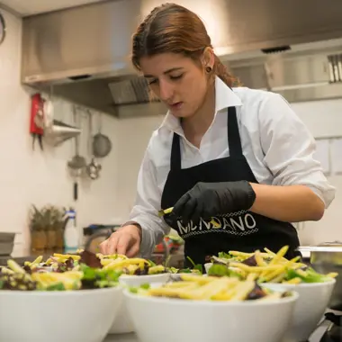 Medewerker in verssector bereidt met zorg gerechten voor in professionele keuken