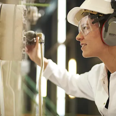 Technisch medewerker controleert nauwkeurig apparatuur in procesindustrieomgeving