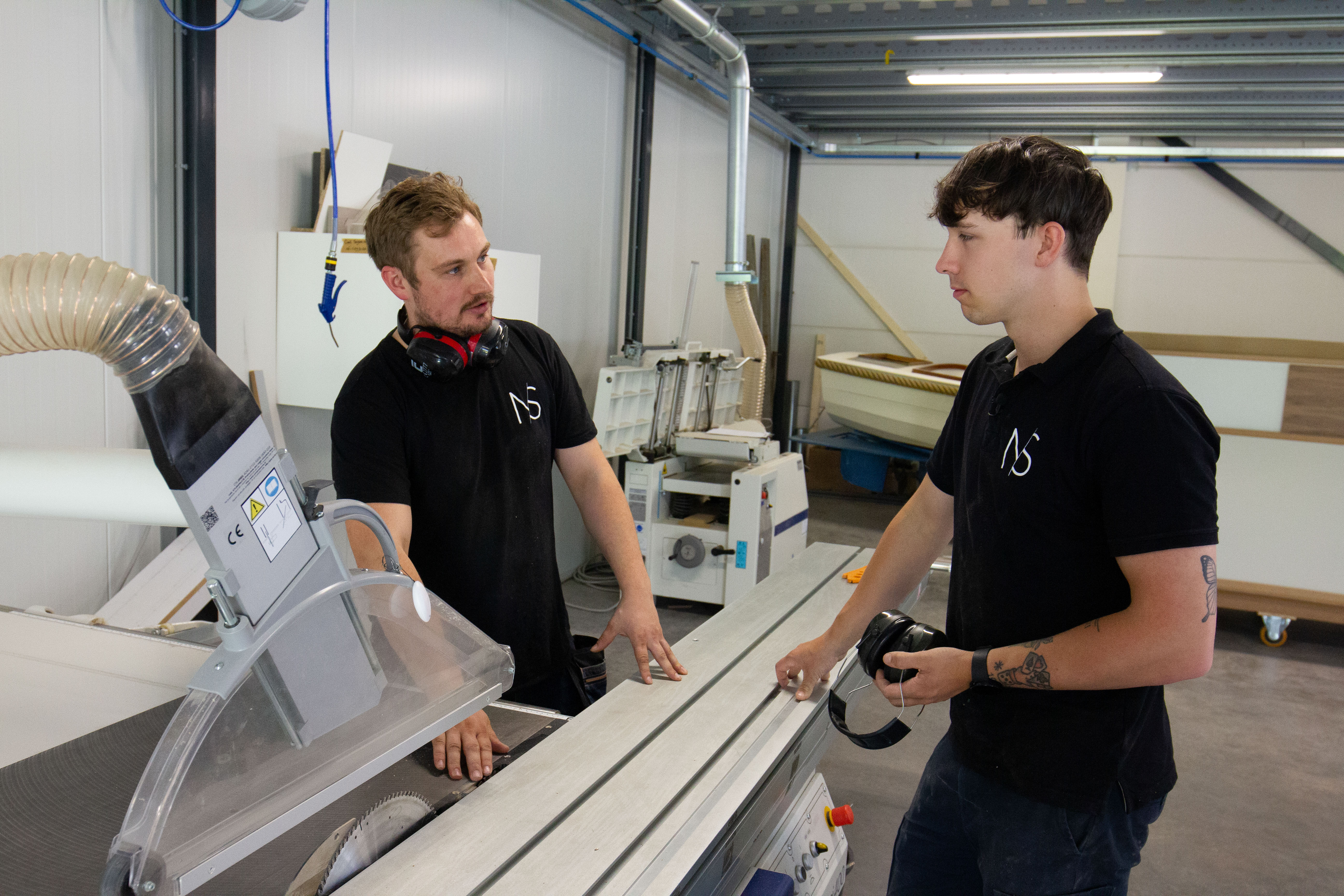 Twee studenten voeren houtbewerking uit in een werkplaats tijdens opleiding ondernemend meubelmaker