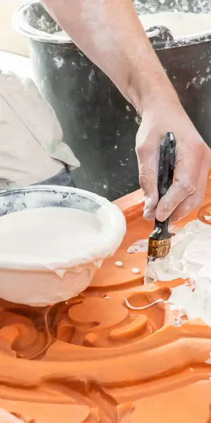 Student oefent met aanbrengen van decoratief stucwerk op een mal tijdens de opleiding decoratiestukadoor