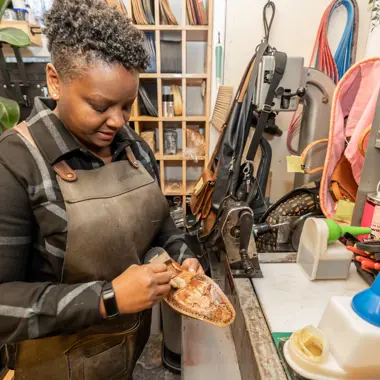 Vakman repareert handgemaakt schoenen met precisie en aandacht voor detail in werkplaats