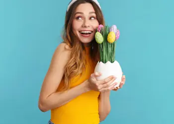 Jongere bekijkt enthousiast een decoratief bloemstuk met paasbestemming als inspiratie bij studiekeuze.