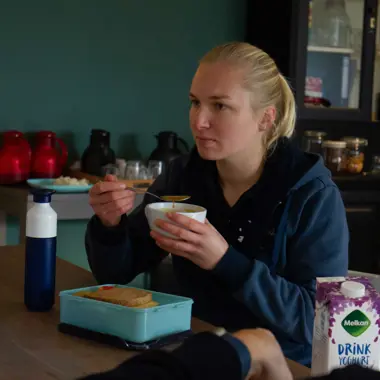 Student tijdens een ontbijt of lunch in een gezamenlijke ruimte, in een informele sfeer