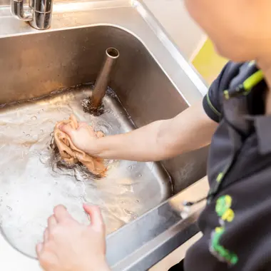 Student oefent het reinigen van een medisch apparaat in een praktijkruimte voor gezondheidstechniek.