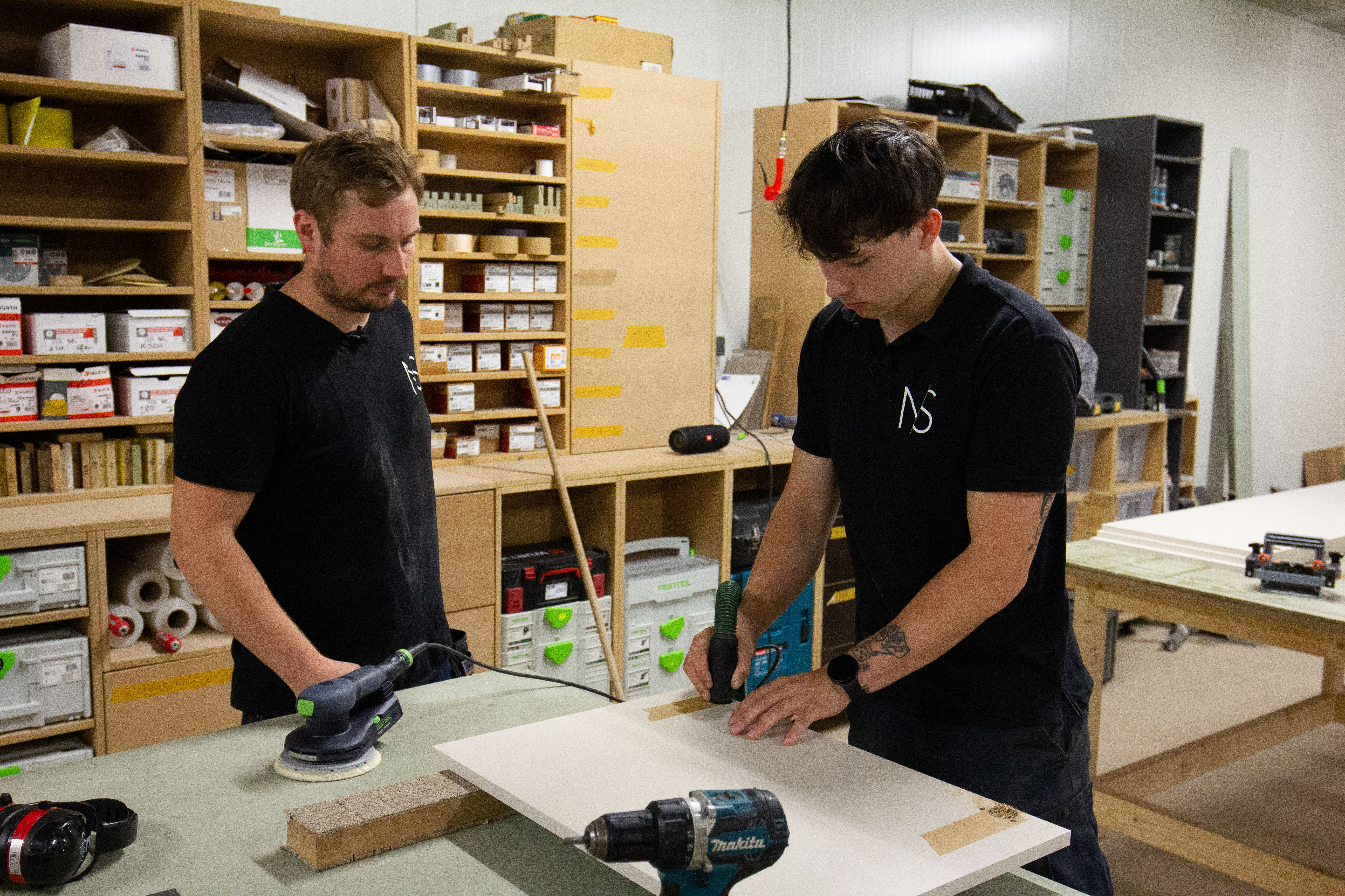 Twee mbo-studenten houtbewerking passen technieken toe in een werkplaats voor meubelmakerij en scheepsinterieur