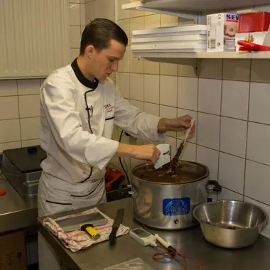 Student leert chocolade bereiden in professionele keuken als onderdeel van bakkerijopleiding