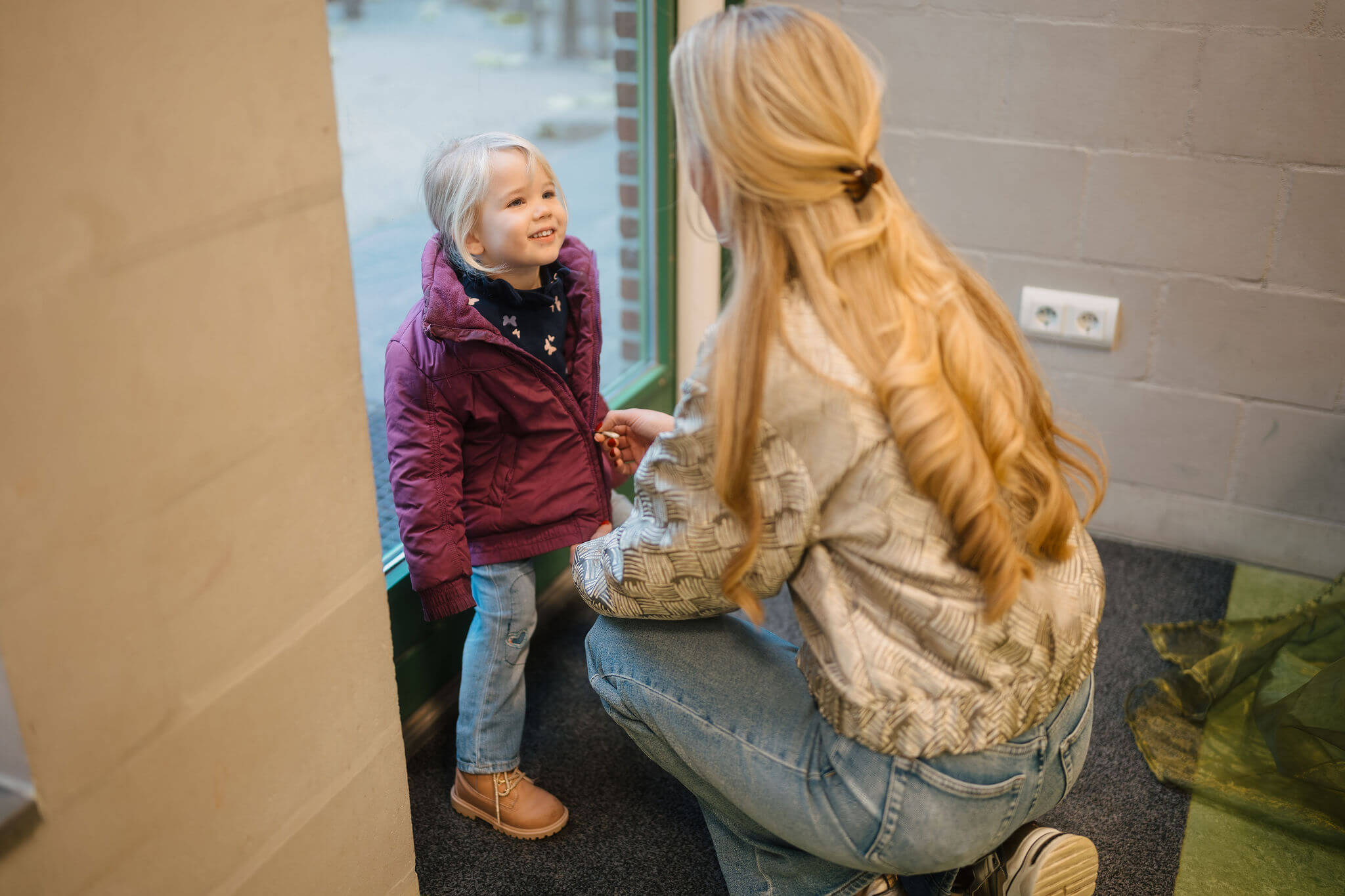 Begeleider praat met jongere die net binnenkomt, begin van een kennismaking in huiselijke omgeving