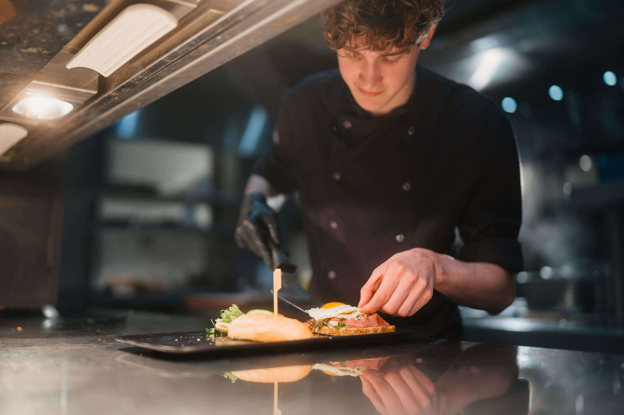 Een kok bereidt zorgvuldig een gerecht voor in een professionele keuken als onderdeel van de koksopleiding.